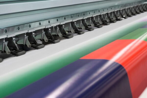 The bond paper output of a wide-format printer showing a spectrum of primary printed colors up close.